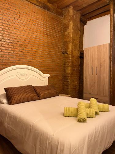 a large white bed with yellow pillows on it at Esencias de la Alhambra in Granada