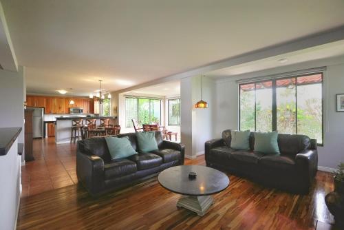 a living room with two leather couches and a table at Villas Aracari in Alajuela