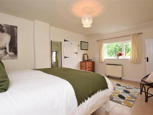 a bedroom with a large white bed and a window at 2 Bed in Bampton SHAYN in Huntsham