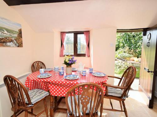 a dining room with a table with a red and white polka dot table cloth at 3 Bed in Bude PORTH in Morwenstow