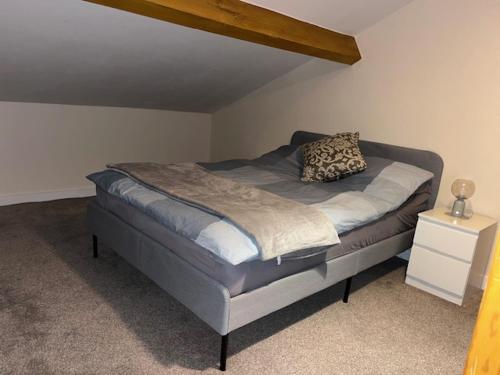 a bed with a pillow on it in a bedroom at Silk Mill Apartment in Macclesfield