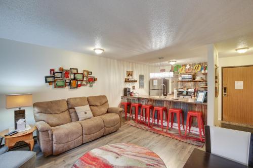 a living room with a couch and a kitchen at Walkable Lead Condo 5 Mi to Terry Peak Ski Area! in Lead