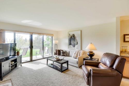 a living room with a couch and a tv at Beautiful Bigfork Condo with Hot Tub Access! in Bigfork