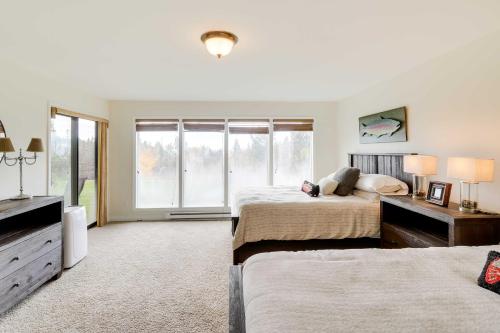 a bedroom with two beds and a large window at Beautiful Bigfork Condo with Hot Tub Access! in Bigfork