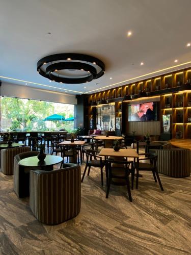 a restaurant with tables and chairs and a flat screen tv at Grand Fiesta Americana Guadalajara Country Club in Guadalajara