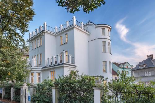 a white house with a fence in front of it at Apartments Villa Whitehouse in Ostrava