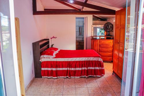a bedroom with a red bed in a room at Aconchegante e lindo Apartamento da Graça perto do aeroporto e melhor churrascaria in Porto Seguro
