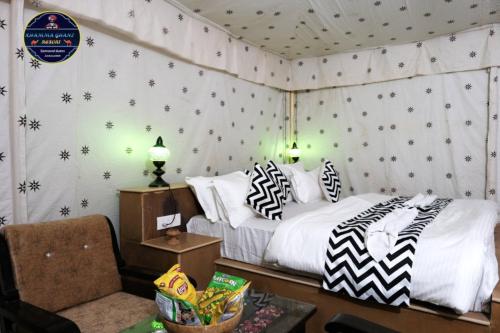 1 dormitorio con 1 cama con almohadas blancas y negras en Khamma Ghani Jaisalmer en Jaisalmer