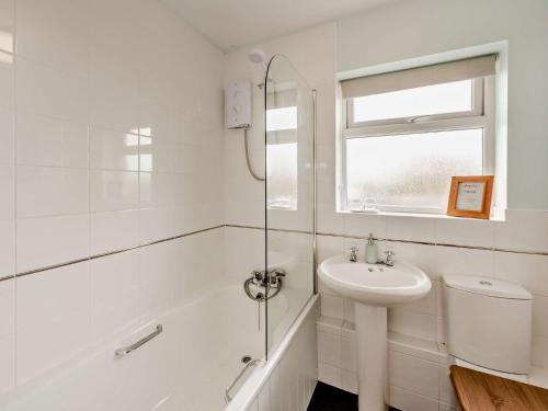 La salle de bains blanche est pourvue d'un lavabo et d'une douche. dans l'établissement 1 Bed in Great Torrington 89636, à Great Torrington