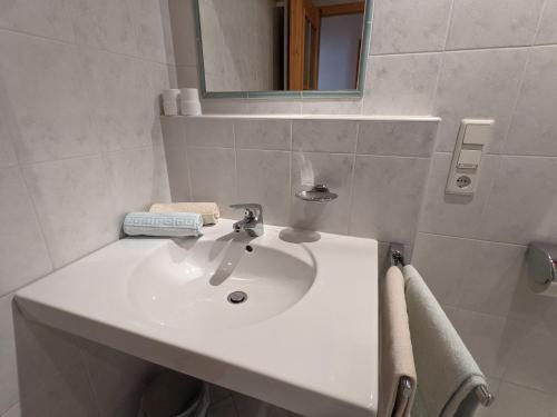 een badkamer met een witte wastafel en een spiegel bij Appartement Egart 2 in Resia