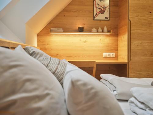 a bed with white pillows in a room at Mountain Lovers Three by AA Holiday Homes in Tauplitz