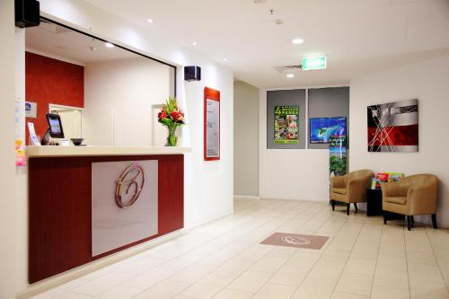 a waiting room with a reception counter and chairs at Cairns Central Plaza Apartment Hotel Official in Cairns