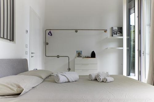a white bedroom with towels on a bed at Il Giardino Segreto in Sacile