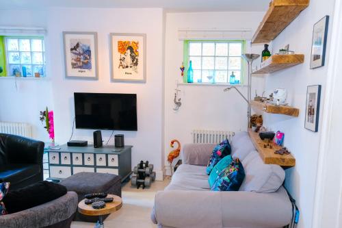 a living room with a couch and a tv at Cute & cosy 1 double bedroom garden flat in Brighton & Hove