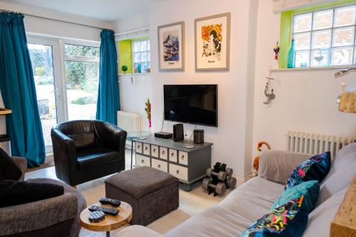 a living room with a couch and a tv at Cute & cosy 1 double bedroom garden flat in Brighton & Hove