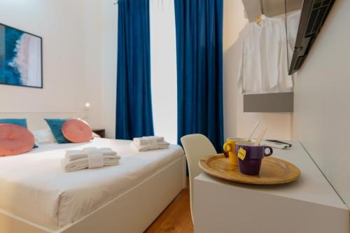Cette chambre comprend 2 lits et une table avec une plaque de cuisson. dans l'établissement CrossRoad Four - locazione turistica, à Cagliari
