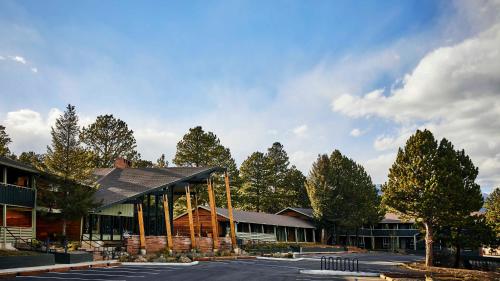 un bâtiment dans un parking avec des arbres en arrière-plan dans l'établissement Trailborn Rocky Mountains, à Estes Park