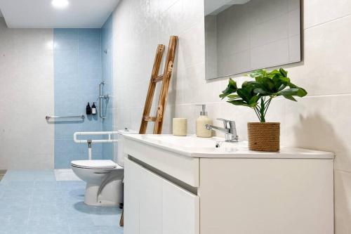 a bathroom with a white sink and a toilet at Apartamentos Gredos 001 in Jaraiz de la Vera