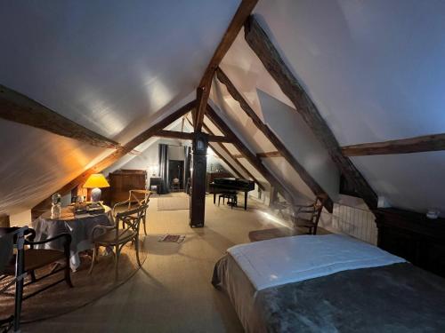 1 dormitorio con cama, mesa y piano en Petit loft de charme proche VERSAILLES SACLAY 30 mn PARIS jardin terrasse parking securisé, en Janvry