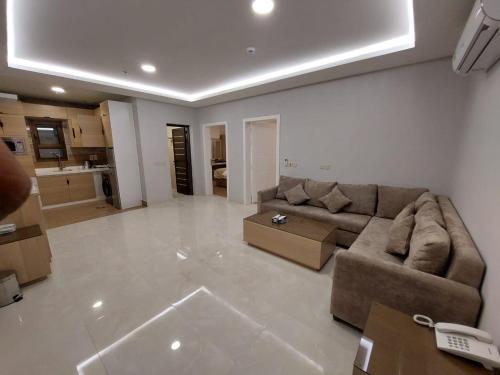 ein großes Wohnzimmer mit einem Sofa und einem Tisch in der Unterkunft شقق كيان البستان للشقق المخدومة in Al-Hasa