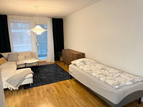 a living room with a large bed and a couch at JATKASAARI-2 - Chic and cosy Sea side stay in Helsinki