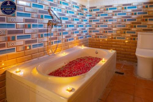 a bathroom with a tub filled with red peppers at Khamma Ghani Jaisalmer in Jaisalmer