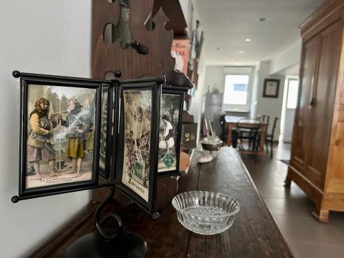 a room with a table with pictures on the wall at Maison Pi Mouss' à 150m de la mer in Cayeux-sur-Mer