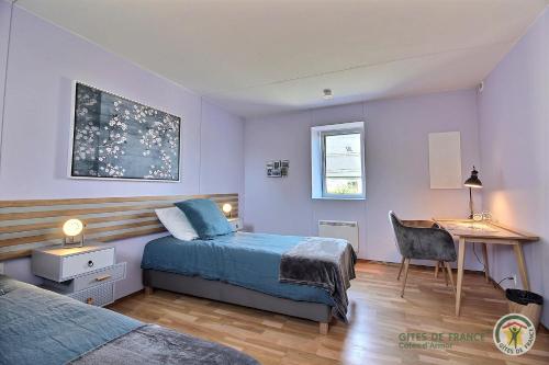 a bedroom with a bed and a desk and a table at La maison de lannion in Lannion