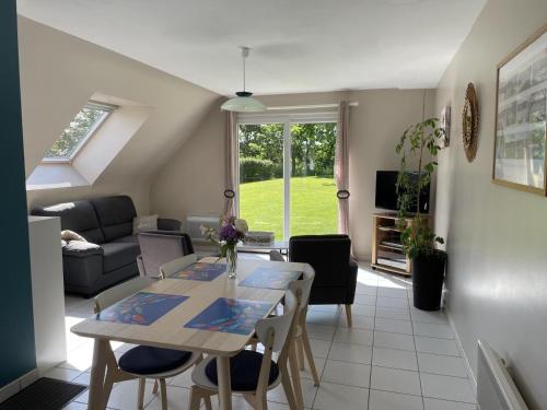 un salon avec une table et un canapé dans l'établissement La petite maison, à Quemper-Guézennec