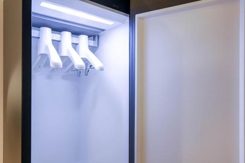 a closet with a door with a bunch of hangers at The Hyoosik Aank Hotel Daejeon Yooseong Hot Spring 1st Branch in Daejeon