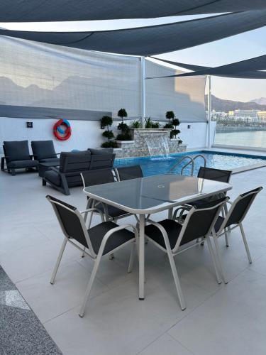 a patio with a table and chairs and a pool at Al Dana Sea View Villa in Fujairah