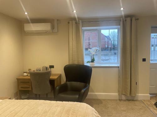 a bedroom with a bed and a desk and a window at The Green Inn in Goole