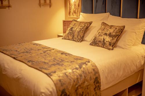 sypialnia z dużym łóżkiem z białą pościelą i poduszkami w obiekcie Hotel Holloway w Birmingham