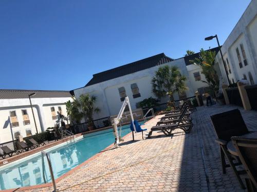 a hotel with a swimming pool in front of a building at Orlando Palms in Orlando