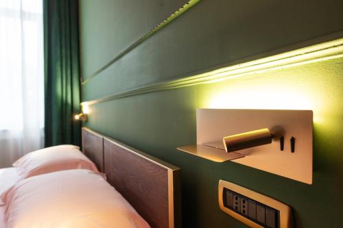 a bedroom with two beds and a light on the wall at Momento Soggiorno di Charme in Foggia