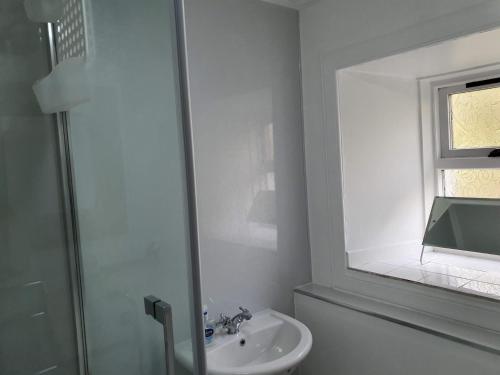 a white bathroom with a sink and a mirror at 1 bed property in Lochinver The Highlands SU304 in Lochinver