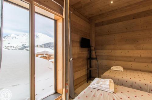 a room with a view of a snowy mountain at Chalet Le Gypaète in Le Grand-Bornand