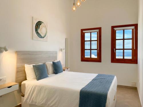 a bedroom with a bed and two windows at Villa Livia Oceanwiew Quiet Eco in Tías