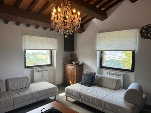 a living room with two couches and a chandelier at Borgo Crispiero in Crispiero