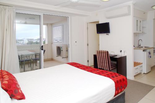 a bedroom with a bed and a desk and a table at Cairns Central Plaza Apartment Hotel Official in Cairns