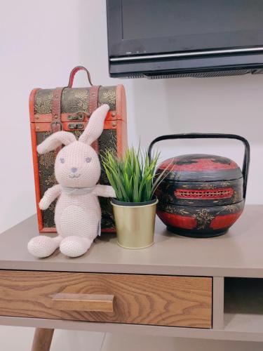 a stuffed rabbit sitting on a shelf next to a potted plant at WAGHEIH KOMEY HOMESTAY in Putrajaya