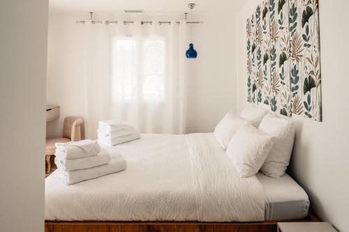 une chambre avec un lit avec des draps blancs et des oreillers dans l'établissement Villa Maria: Piscine privative chauffée* Sauna Borne recharge vhl, à Goudargues