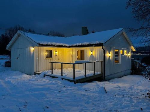 uma casa com luzes na neve à noite em Ivar and Sofies House em Tromsø
