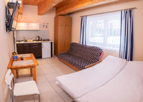 a living room with a bed and a kitchen at Domki Ajna Park w uzdrowisku in Kołobrzeg