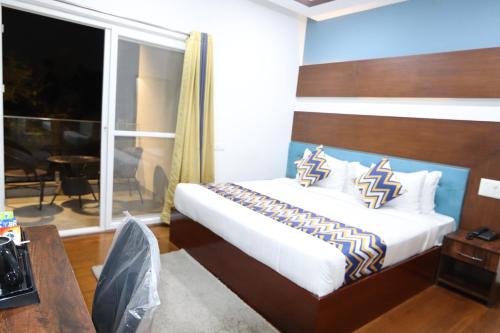 a bedroom with a bed and a large window at Athulya Residence Suite Rooms in Bengaluru