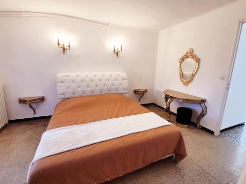 een slaapkamer met een groot bed en een spiegel bij Le Mas Montserrat in Le Luc