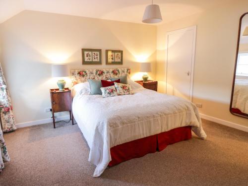 Un dormitorio con una cama grande y una ventana en The Stables, en Dumfries