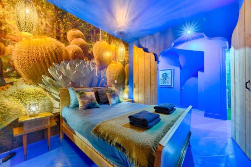 a bedroom with a bed in a room with blue walls at Luxury Jardin Majorelle paris orly avec jacuzzi in Vigneux-sur-Seine