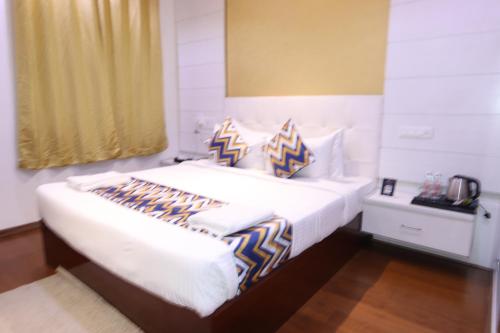 a bedroom with a bed with blue and white pillows at Athulya Residence Suite Rooms in Bengaluru