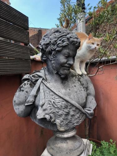 a cat sitting on top of a statue of a woman at Studio Rempart in Brussels